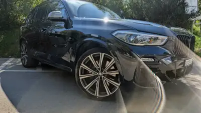 BMW X5 M50d xDrive — SUV prestige diesel 400ch, full black, révisions BMW incluses — fianco