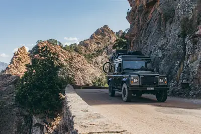 Land Rover Defender 110 TD4 — Aménagement camping avec toit relevable, 4x4 fiable — côté