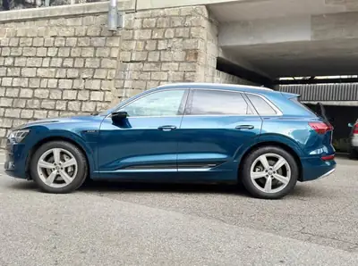 Audi e-tron 55 quattro — SUV électrique premium, 360 ch et design vert métallisé — side view