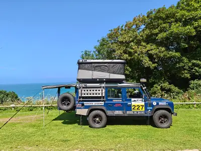 Land Rover Defender 110 SW — Véhicule d'expédition tout-terrain avec équipements de camping — vue extérieure