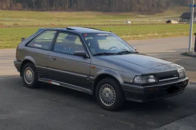 Mazda 323 1.6i GTX Turbo 4WD — Berline compact des années 80, turbo et traction intégrale — vista esterna