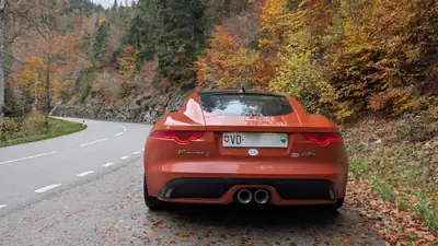 Jaguar F-TYPE 3.0 V6 S AWD — Coupé sportif orange métallisé, 380 ch et traction intégrale — side view